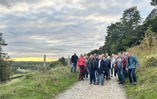 Large group on a ridge path with wide countryside views at sunset near Dorking.