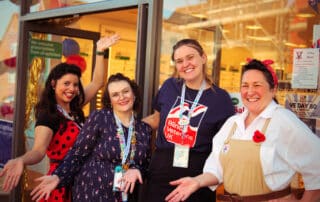 Women in vintage 1940s clothing at VE Day celebrations outside Specsavers in Dorking