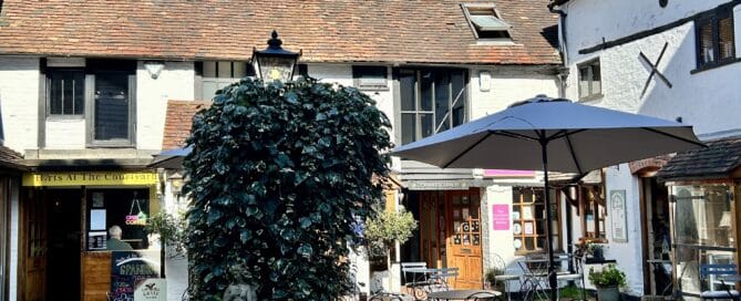Old Kings Courtyard in Dorking with independent shops, outdoor seating, and St Martin's Church spire