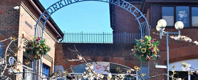 Dorking Market arch entrance with spring hanging baskets and cherry blossom